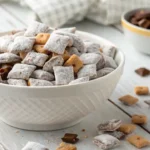 Bowl of homemade Muddy Buddies coated in powdered sugar