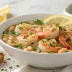 A bowl of lemony shrimp and bean stew garnished with parsley