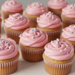 Frosted pink cupcakes on a white cake stand
