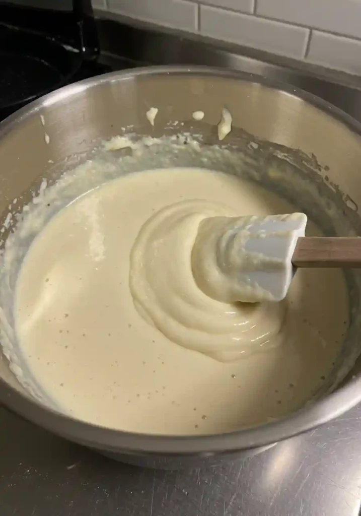 Spatula stirring thick pancake batter in a large bowl
