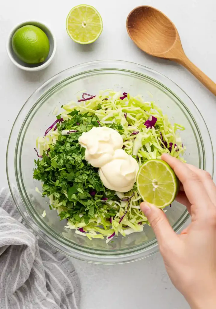 Cabbage, mayo, lime juice, and cilantro mixed in bowl