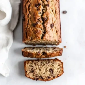 A moist slice of banana bread on a plate with butter