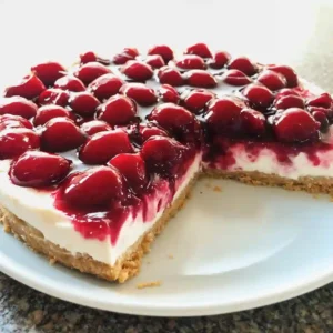 Sliced no bake cherry cheesecake with creamy filling and cherries