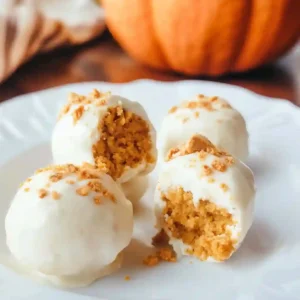 Pumpkin cheesecake balls with white chocolate coating on a platter