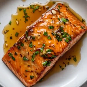 Cooked salmon fillets with golden glaze and lemon wedges