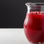 Glass of cranberry juice with ice and lemon slice