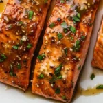 Honey garlic salmon fillets glazed and served with lemon slices