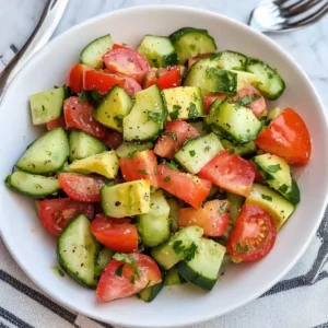 Freshly prepared cucumber tomato avocado salad with herbs and dressing
