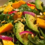 Fresh Avocado Mango Salad with lime dressing served in white bowl, garnished with cilantro and lime wedges