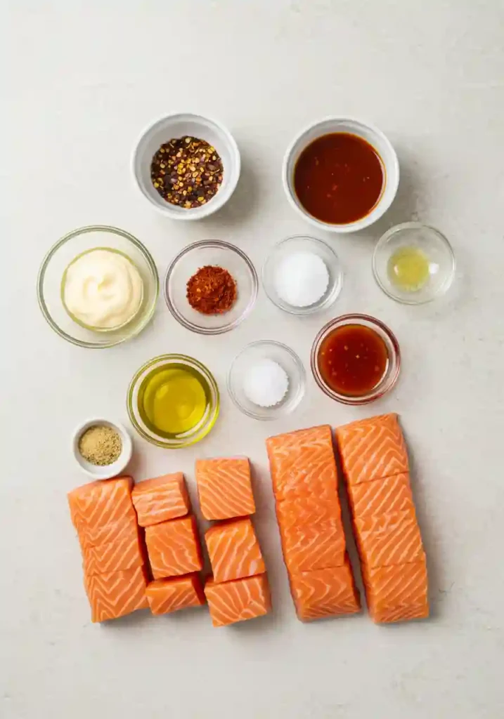 Prepped ingredients including salmon, spices, chili sauce, mayo, and rice