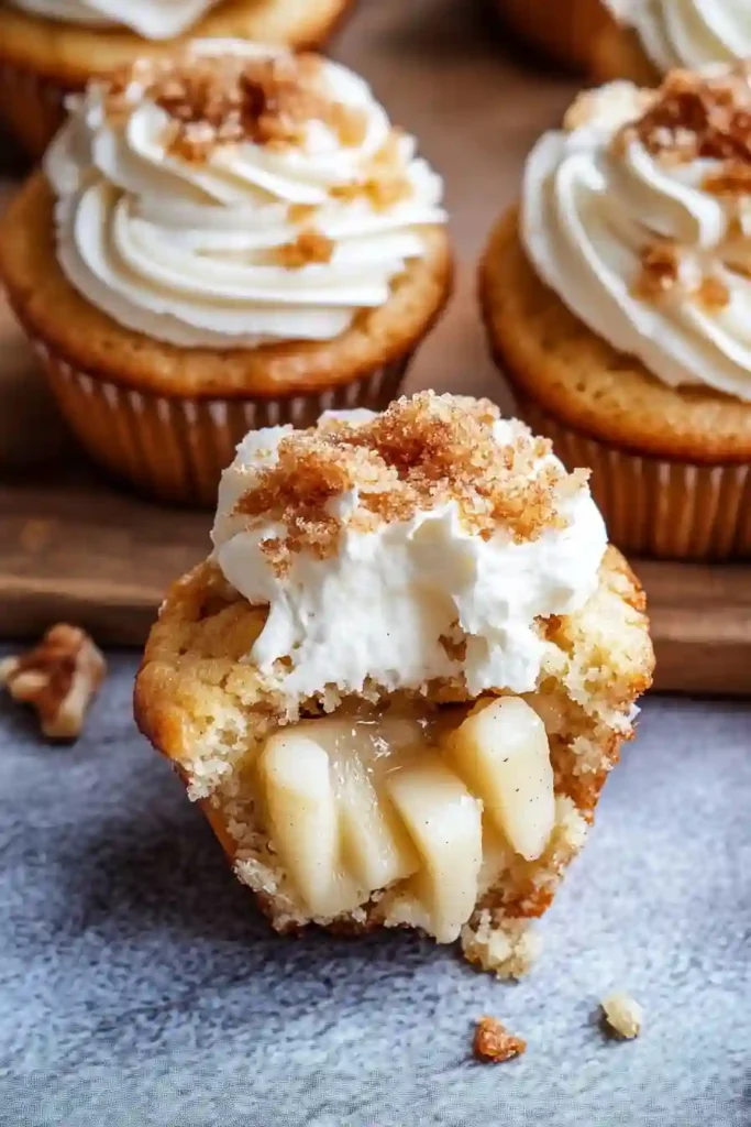 Piping Cinnamon Buttercream onto Apple Filled Cupcakes