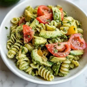 Finished bowl of Avocado Pasta Salad garnished with seeds and herbs